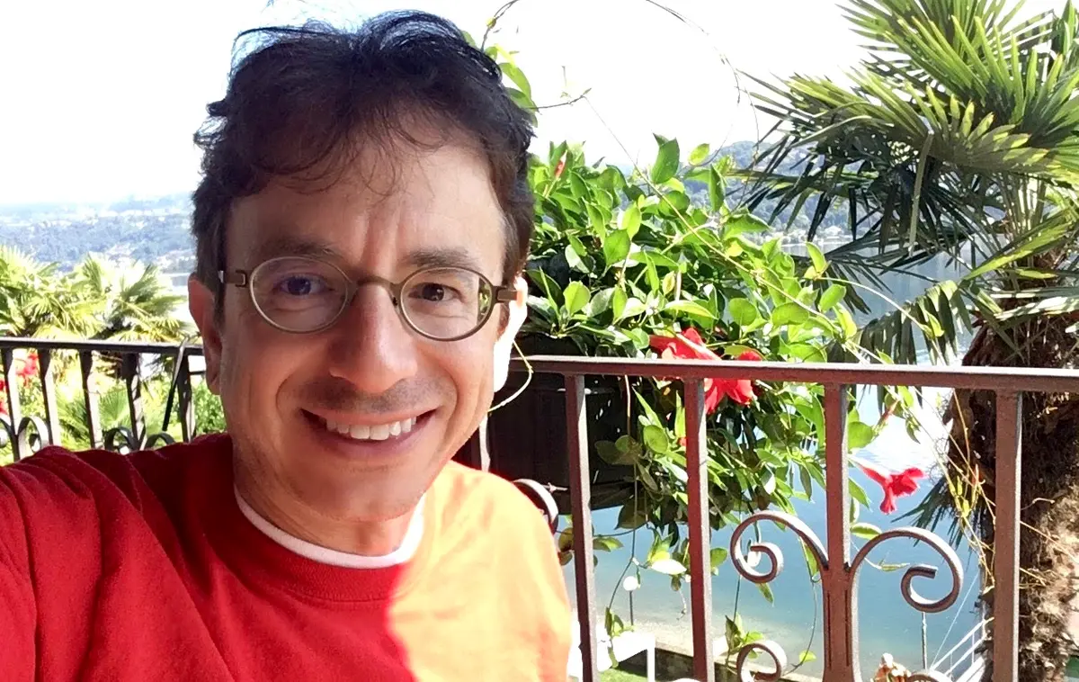Image of Todd T taking a selfie with a tropical beach in the background.