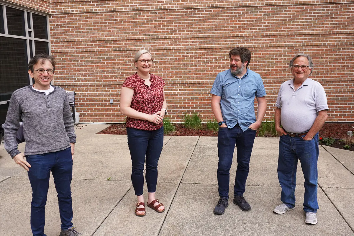 Todd Tannenbaum, Mary Hester, Brian Bockelman, and Miron Livny standing outside smiling